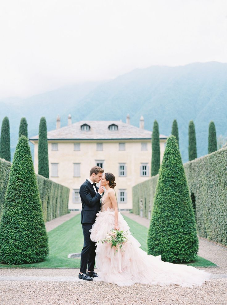 Romantic bride and groom portrait in elegant garden with villa backdrop fine art wedding photography soft light luxury outdoor wedding couple
