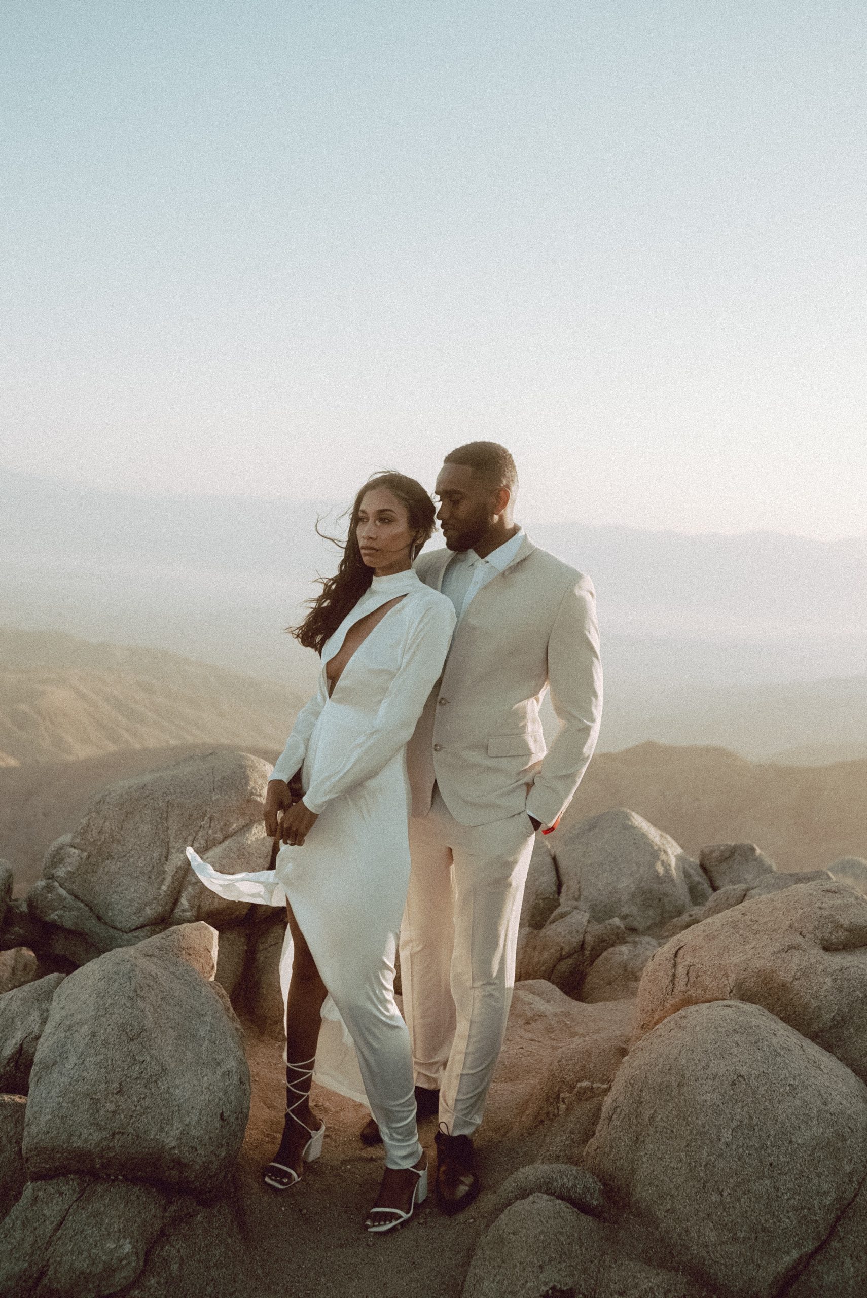 Cinematic wedding couple portrait on rocky landscape at sunset outdoor destination wedding