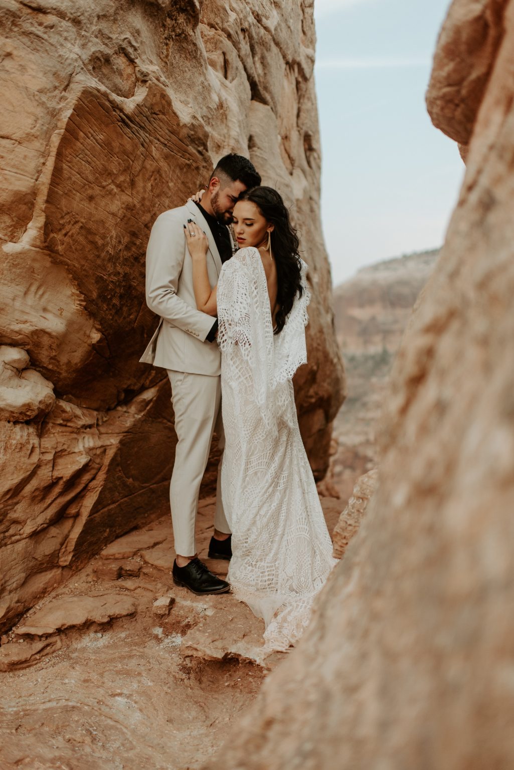 Intimate desert elopement wedding couple portrait among sandstone cliffs romantic boho destination wedding photography