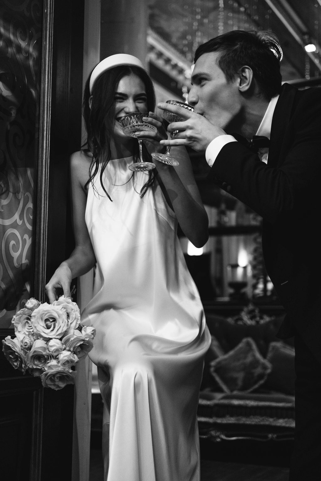 Cinematic wedding couple enjoying champagne at elegant indoor reception with candid moment