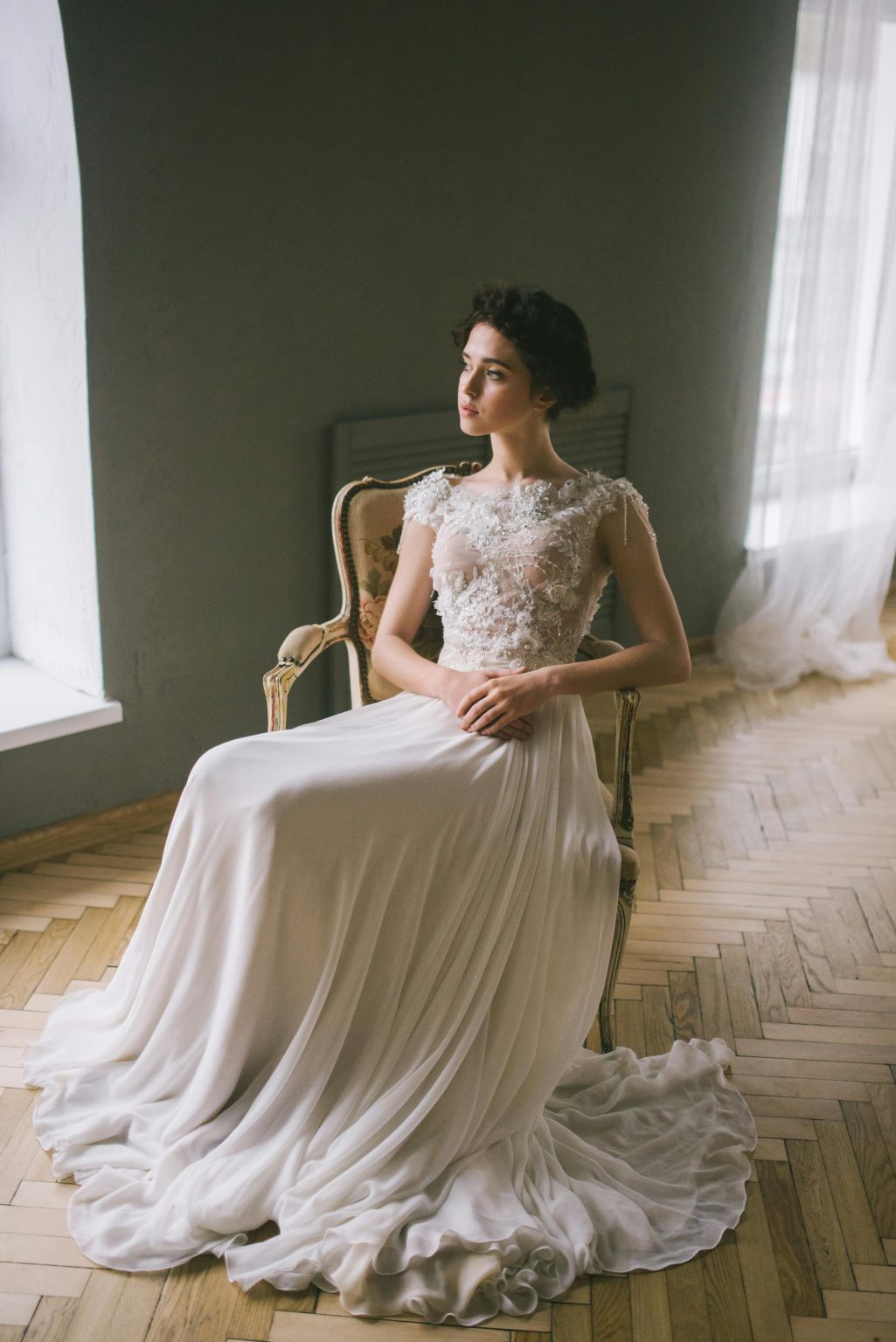 Luxury wedding videographer capturing editorial bridal portrait in soft natural window light