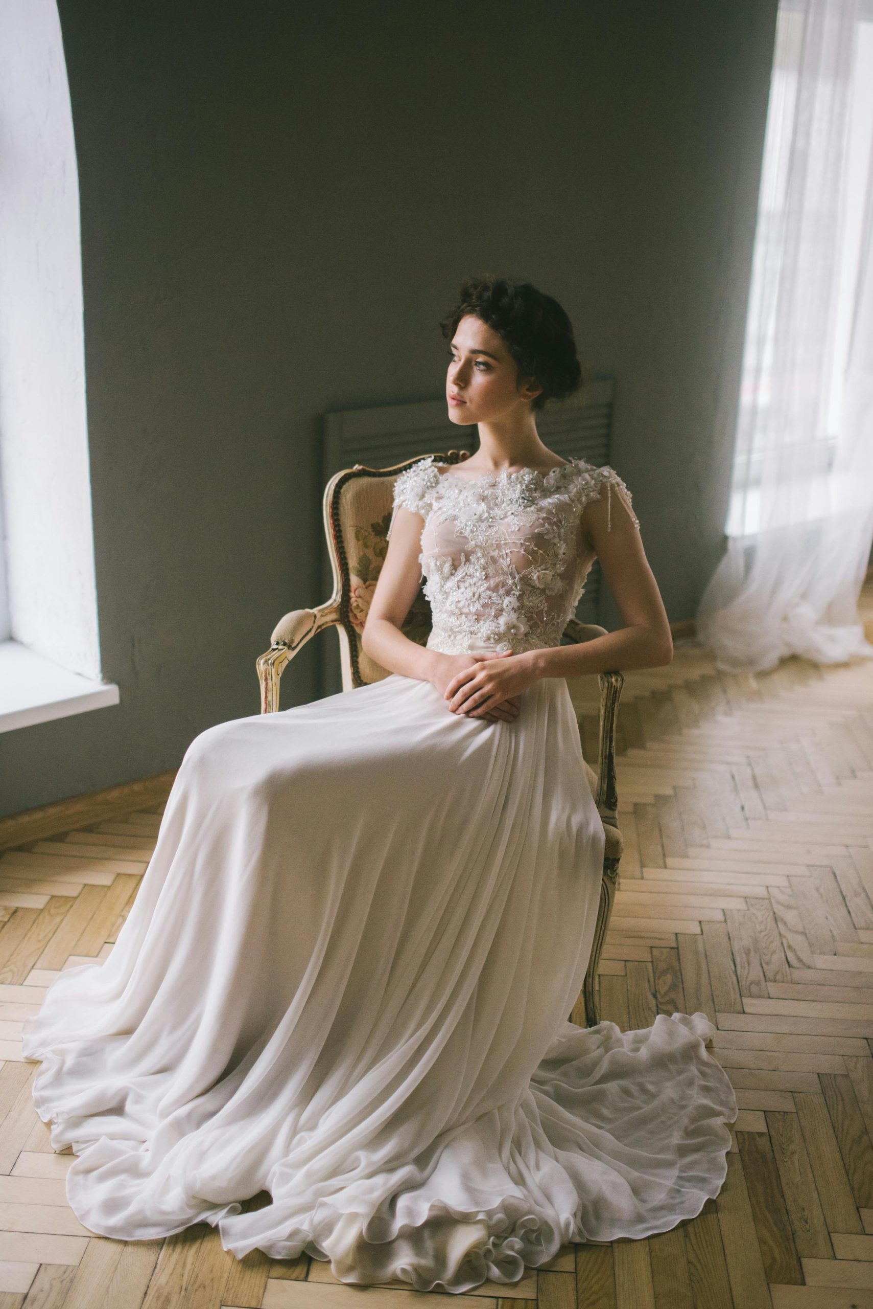 Luxury wedding videographer capturing editorial bridal portrait in soft natural window light