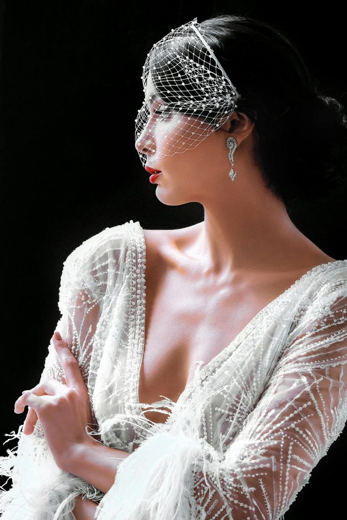 Luxury wedding videographer capturing editorial bridal portrait with veil and lace gown