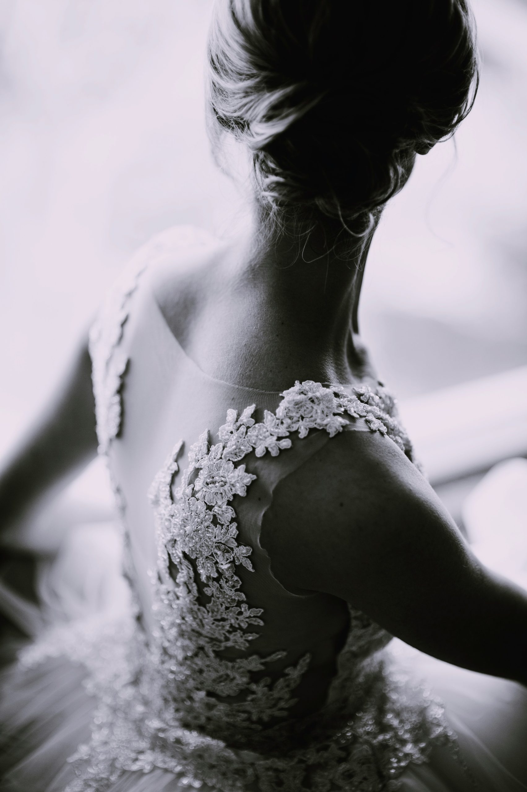 Luxury wedding videographer capturing bridal lace dress detail in soft light